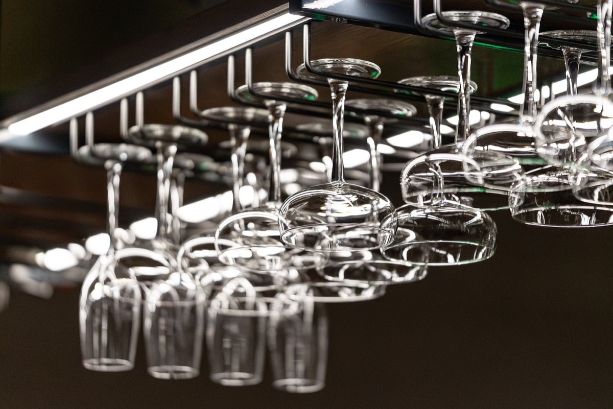 Person pouring clean filtered water from a pitcher into a glass in a modern kitchen